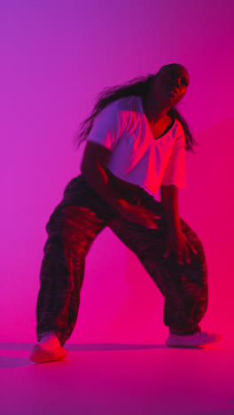 Foto-De-Estudio-De-Vídeo-Vertical-De-Una-Joven-Bailarina-Bailando-Sobre-Un-Fondo-Iluminado-En-Azul-Y-Rosa-1